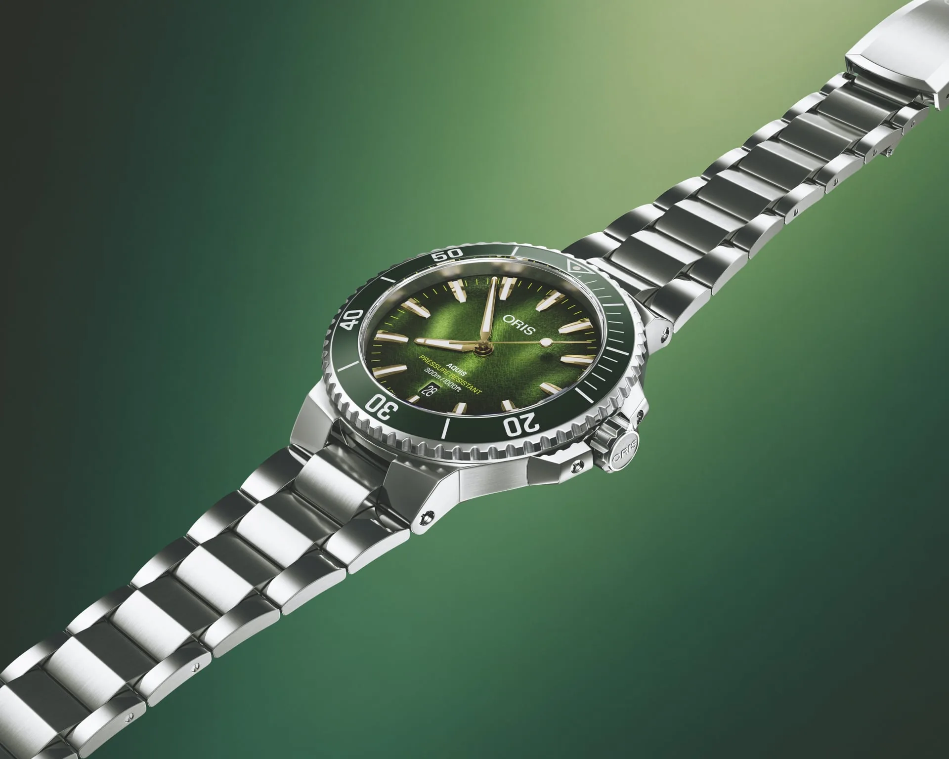Oris Aquis Kelp Forest Limited Edition teräsrannekkeella vihreällä taustalla.